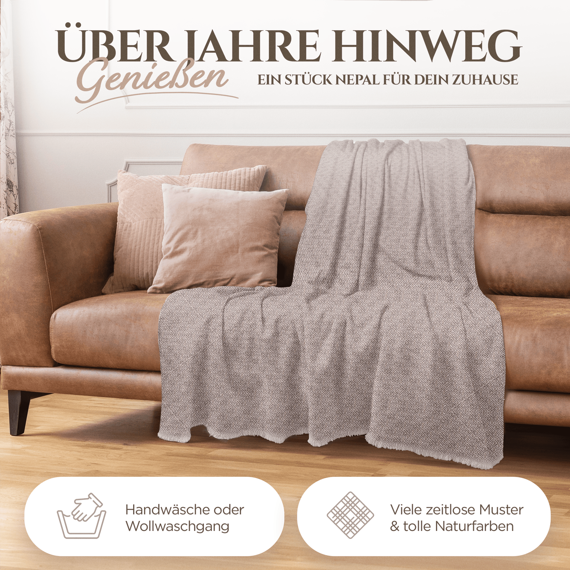 Auf einem hellbraunen Sofa liegt eine graubraune Kaschmirdecke mit feinem Karomuster, daneben mehrere beige Kissen.